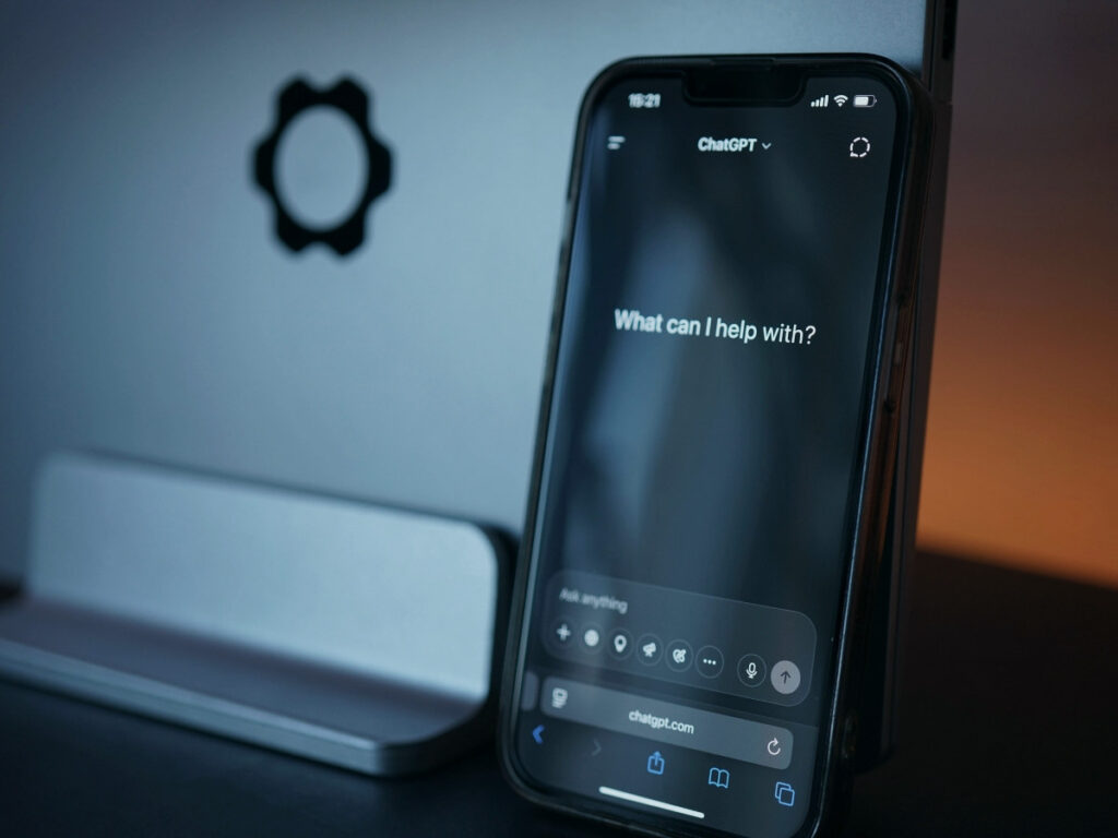 Telefon z uruchomionym asystentem AI leżący na biurku