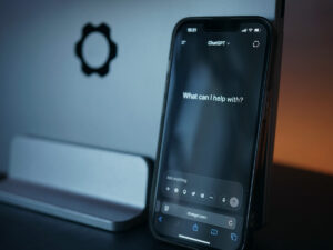 Telefon z uruchomionym asystentem AI leżący na biurku
